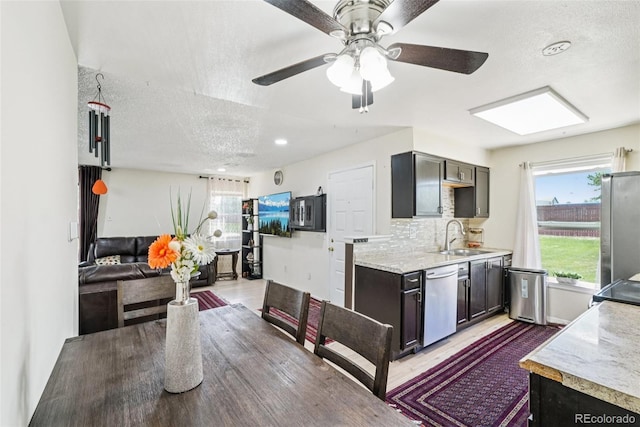 11941 Bellaire St Unit B, Thornton, CO 80233 - kitchen with stainless steel appliances, a textured ceiling, light wood-style flooring, ceiling fan, and tasteful backsplash