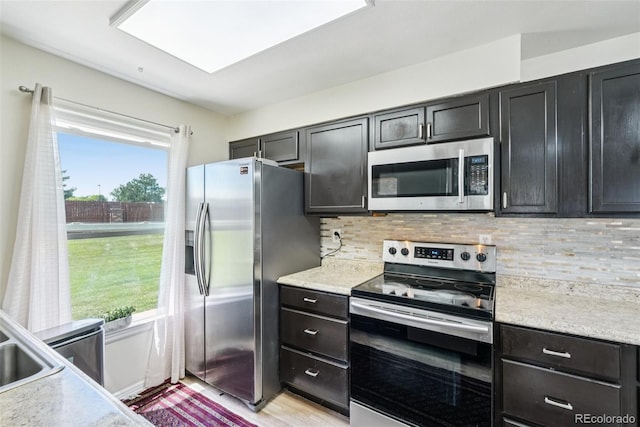 11941 Bellaire St Unit B, Thornton, CO 80233 - kitchen with stainless steel appliances, light countertops, tasteful backsplash, and dark cabinetry