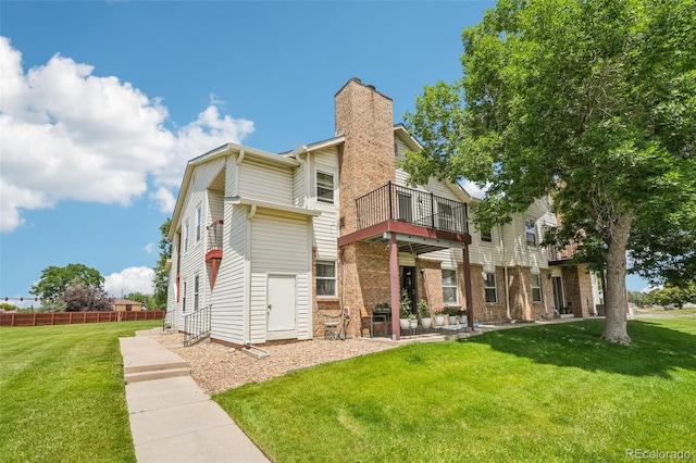 11941 Bellaire St Unit B, Thornton, CO 80233 - rear view of property featuring a chimney, a balcony, and brick siding