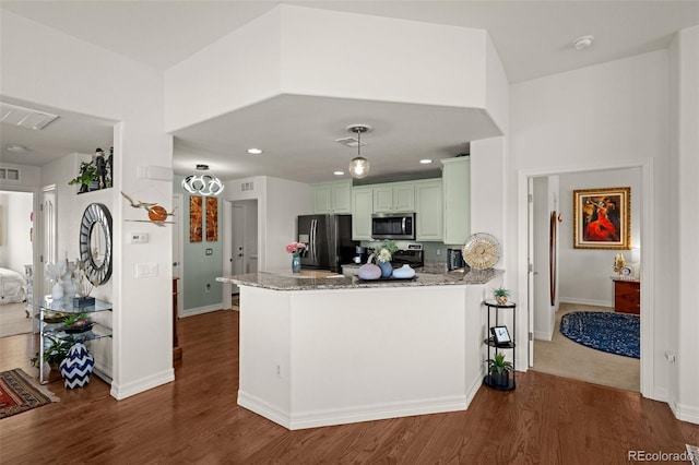 kitchen with stainless steel microwave, light stone countertops, a peninsula, and black refrigerator with ice dispenser