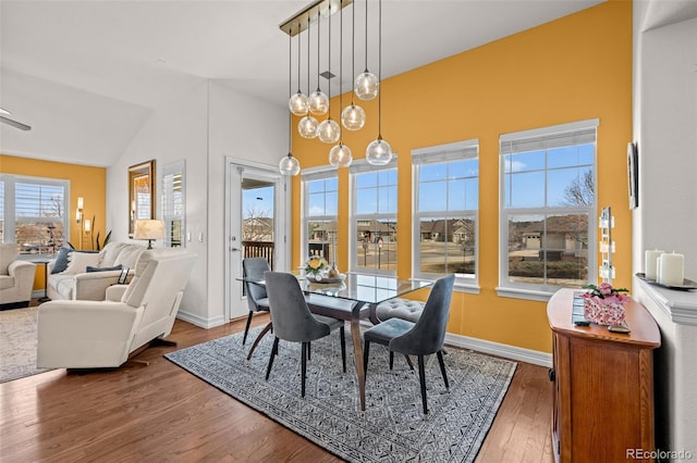 dining room with lofted ceiling, wood finished floors, and baseboards