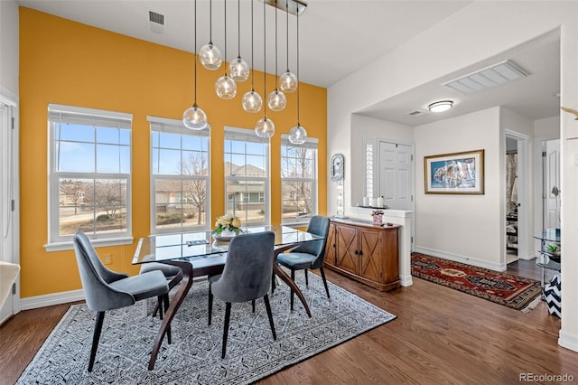 dining area with baseboards, visible vents, and dark wood-style flooring