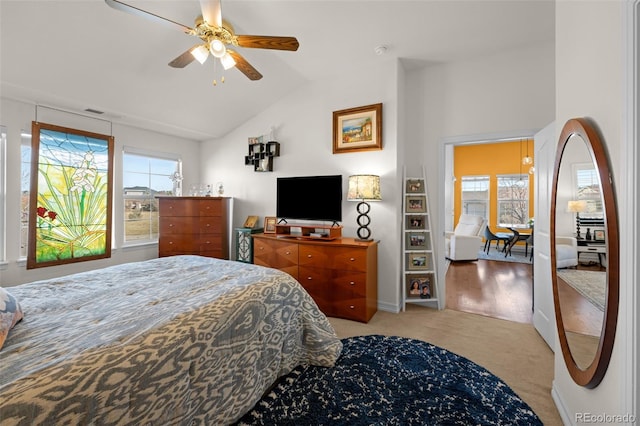 bedroom with light carpet, multiple windows, a ceiling fan, and vaulted ceiling