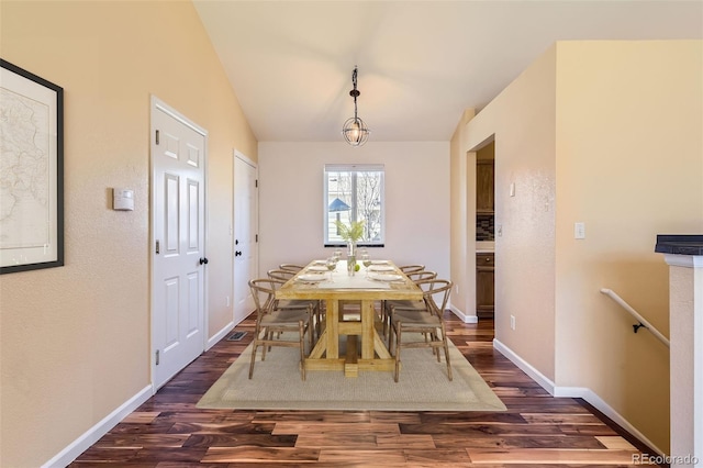 dining area featuring dark wood-type flooring and lofted ceiling