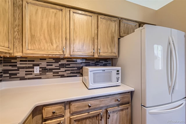 kitchen with tasteful backsplash and white appliances