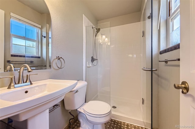 bathroom featuring a shower, sink, and toilet