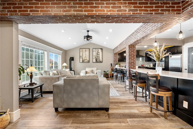 living room featuring light wood-style floors, vaulted ceiling, and recessed lighting