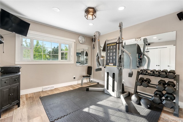 exercise room with wood finished floors, baseboards, and recessed lighting