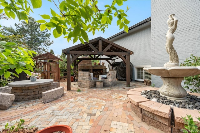 view of patio with a gazebo and an outdoor fireplace