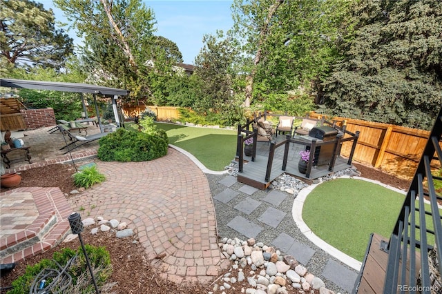 view of patio featuring a fenced backyard, a grill, and a wooden deck