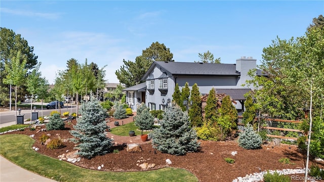 view of side of home with a chimney and fence