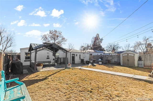 back of house with a gazebo, a yard, outdoor lounge area, a shed, and a patio