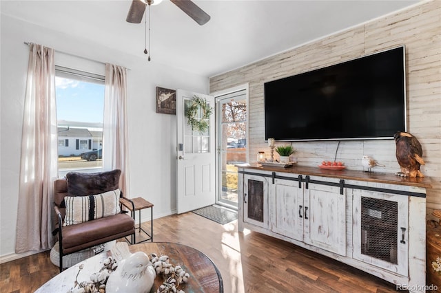 living room with dark wood-type flooring and ceiling fan