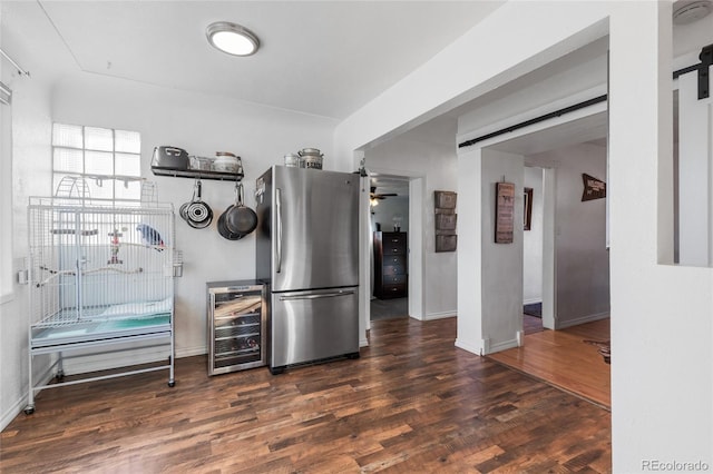 kitchen featuring a barn door, dark hardwood / wood-style floors, wine cooler, and stainless steel refrigerator