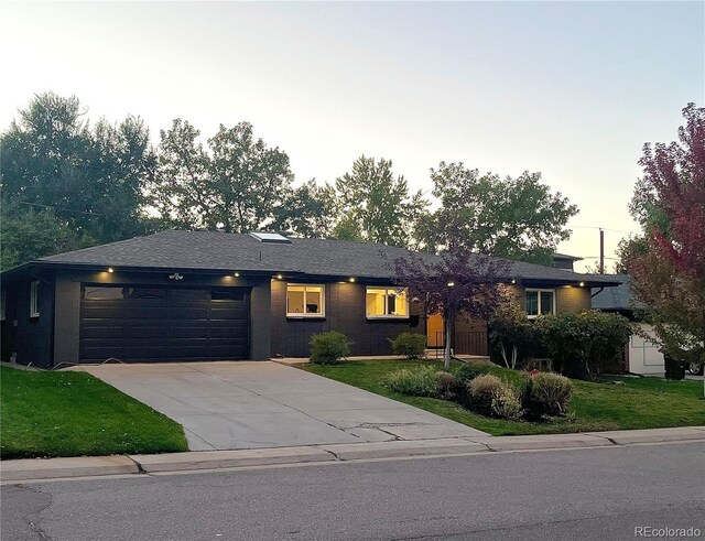 single story home with driveway, a front yard, and a garage