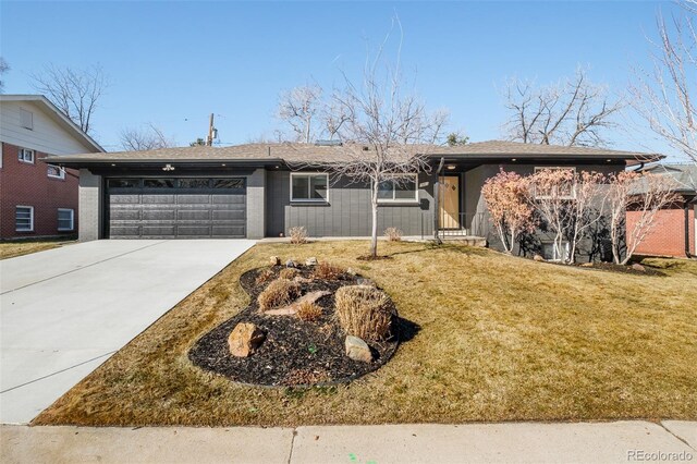 ranch-style house with an attached garage, roof with shingles, a front yard, and concrete driveway