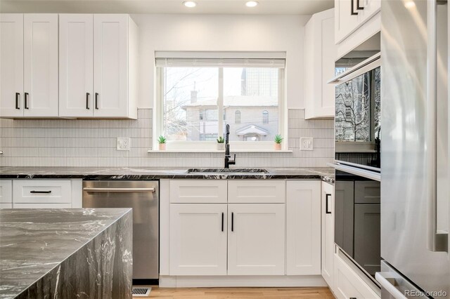 kitchen with recessed lighting, a sink, appliances with stainless steel finishes, and white cabinets