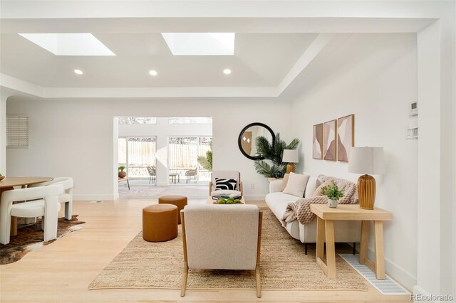 sitting room with recessed lighting, light wood finished floors, baseboards, and a skylight