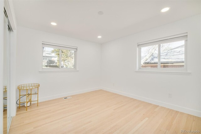 spare room featuring visible vents, recessed lighting, baseboards, and wood finished floors