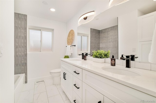 bathroom featuring double vanity, toilet, a sink, and marble finish floor