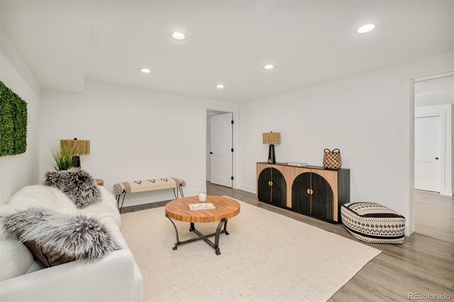 living area with recessed lighting, baseboards, and wood finished floors