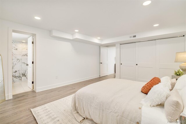 bedroom with visible vents, recessed lighting, light wood-style flooring, and connected bathroom