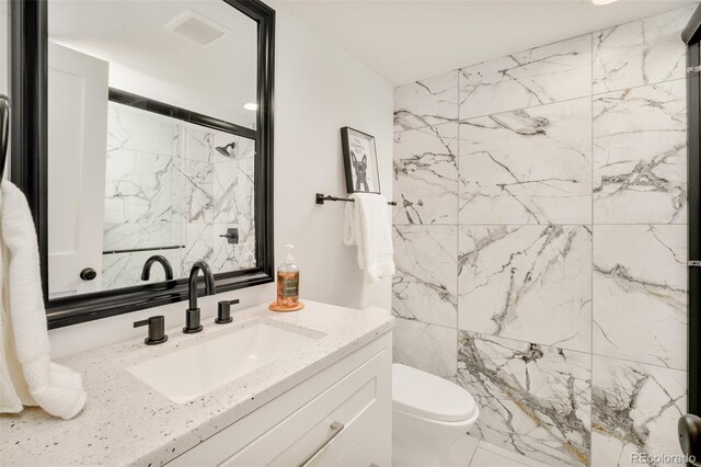 full bathroom featuring visible vents, vanity, marble finish floor, toilet, and a marble finish shower