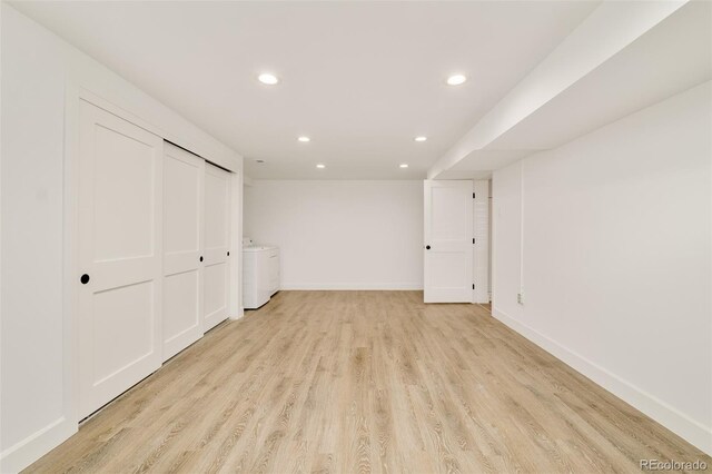 below grade area with light wood-style floors, baseboards, recessed lighting, and washer / clothes dryer