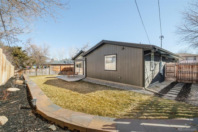 view of side of property with a fenced backyard, a lawn, and a patio area
