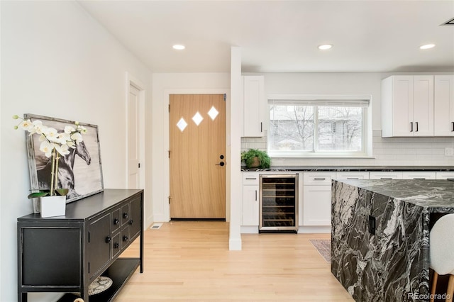 621 S Harrison Ln, Denver, CO 80209 - kitchen featuring wine cooler, backsplash, white cabinets, light wood-style flooring, and recessed lighting