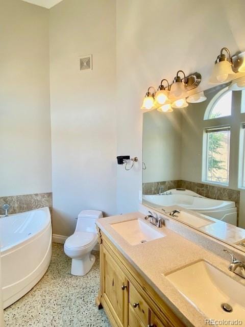 bathroom with vanity, toilet, and a bath