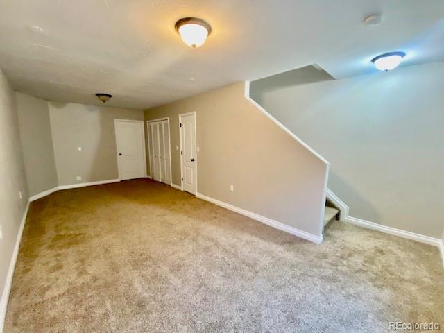 basement featuring light carpet