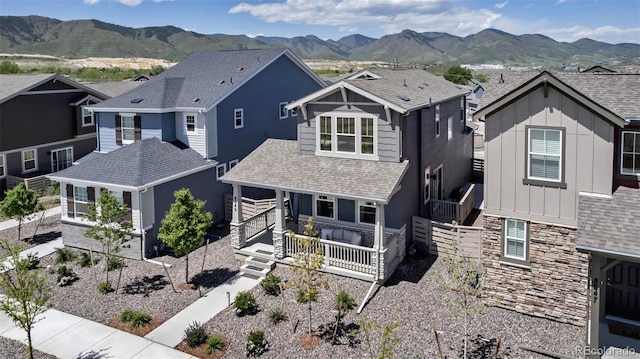 8049 Monte Vista Cir, Littleton, CO 80125 - view of front of home featuring board and batten siding, a mountain view, stone siding, a shingled roof, and a residential view
