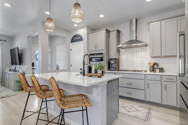 8049 Monte Vista Cir, Littleton, CO 80125 - kitchen with wall chimney range hood, gray cabinetry, stainless steel appliances, recessed lighting, and backsplash