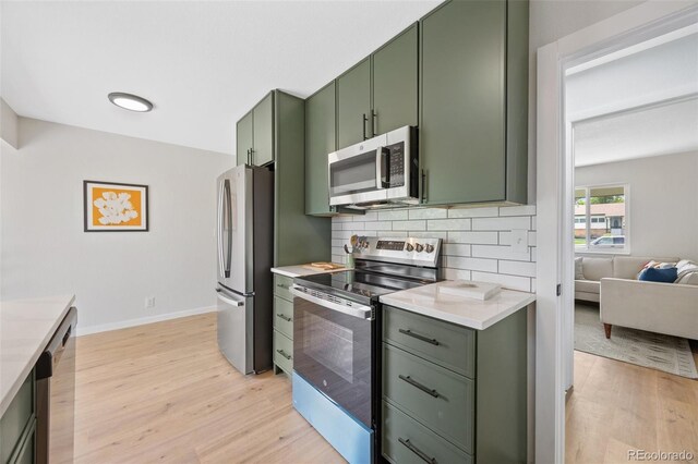 1205 W 101st Ave, Northglenn, CO 80260 - kitchen with green cabinets, stainless steel appliances, light wood-type flooring, light countertops, and backsplash