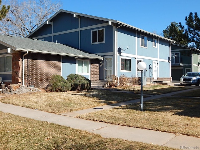 view of front of property featuring a front yard and brick siding