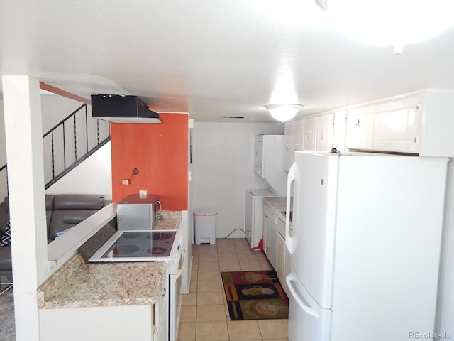 kitchen with light tile patterned floors, light countertops, white appliances, and white cabinetry