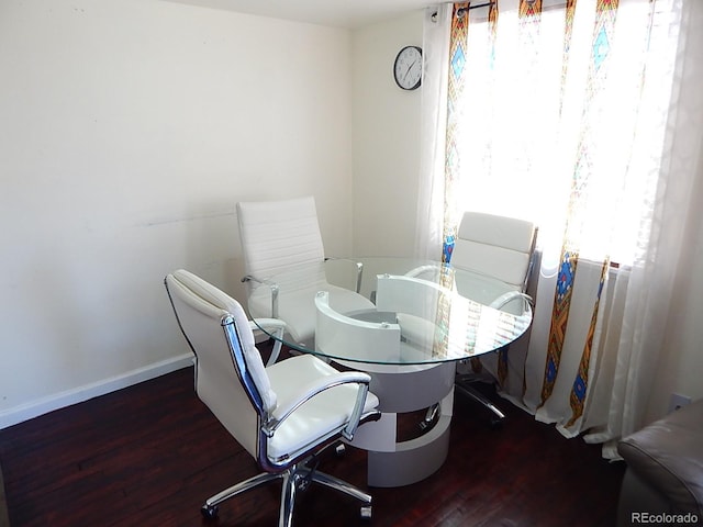 dining space with baseboards and wood finished floors