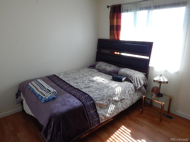 bedroom featuring baseboards and wood finished floors