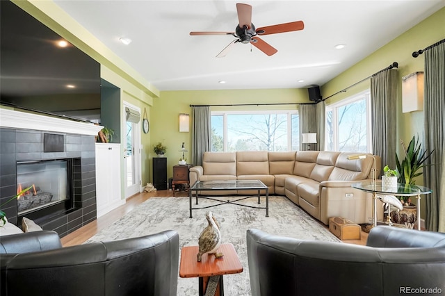 living room featuring a tiled fireplace, recessed lighting, wood finished floors, and a ceiling fan