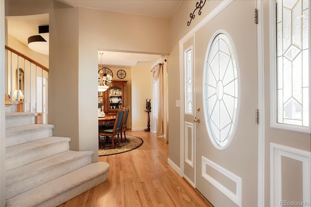 entryway featuring a wealth of natural light, stairway, and light wood finished floors