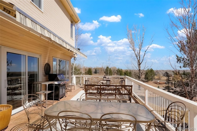 deck with outdoor dining space and grilling area
