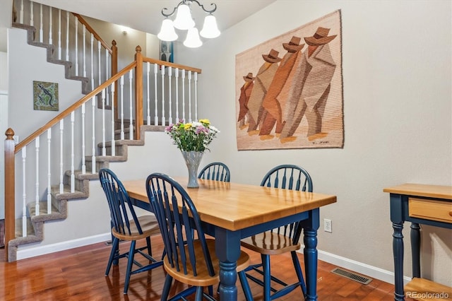 dining area with wood finished floors, visible vents, baseboards, stairs, and a notable chandelier