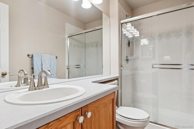 full bathroom featuring vanity, toilet, and a stall shower