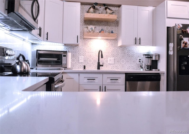 650 S Clinton St Unit 2A, Denver, CO 80247 - kitchen featuring stainless steel appliances, tasteful backsplash, and white cabinetry