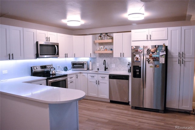 650 S Clinton St Unit 2A, Denver, CO 80247 - kitchen with stainless steel appliances, open shelves, tasteful backsplash, and white cabinetry