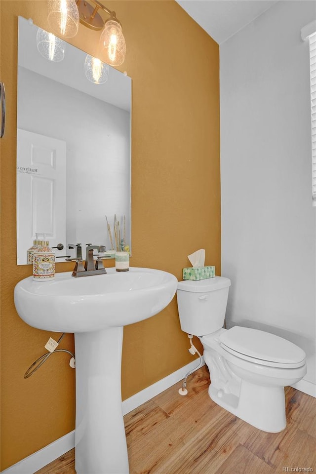 21900 E 46th Pl, Aurora, CO 80019 - half bathroom with toilet, wood finished floors, a sink, and baseboards