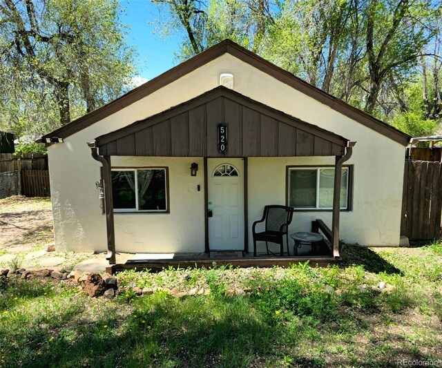 520 Prairie Rd, Colorado Springs, CO 80909 - view of front facade with covered porch, fence, and stucco siding