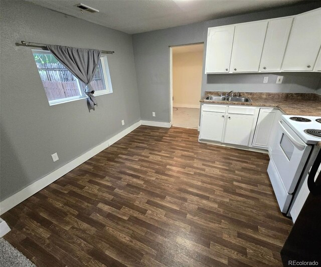 520 Prairie Rd, Colorado Springs, CO 80909 - kitchen with a sink, white range with electric stovetop, dark wood-style floors, white cabinets, and baseboards