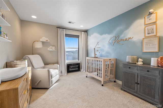 bedroom with a nursery area and light carpet